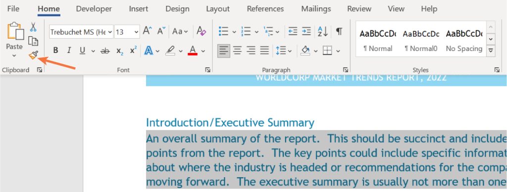 A screenshot of a Microsoft Word document with the Home tab selected. The toolbar displays formatting options including font settings, bold, italic, underline, and paragraph alignment. An orange arrow highlights the 'Format Painter' tool in the Clipboard section. Below the toolbar, the document titled 'WORLD CORP MARKET TRENDS REPORT, 2022' is partially visible, showing introductory text for the executive summary.