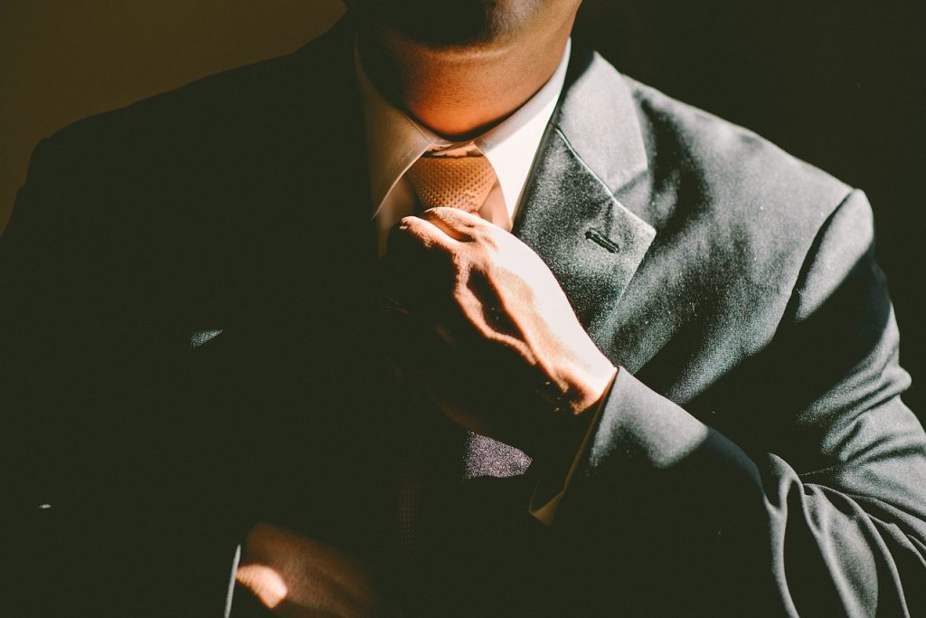 Photo of man adjusting tie