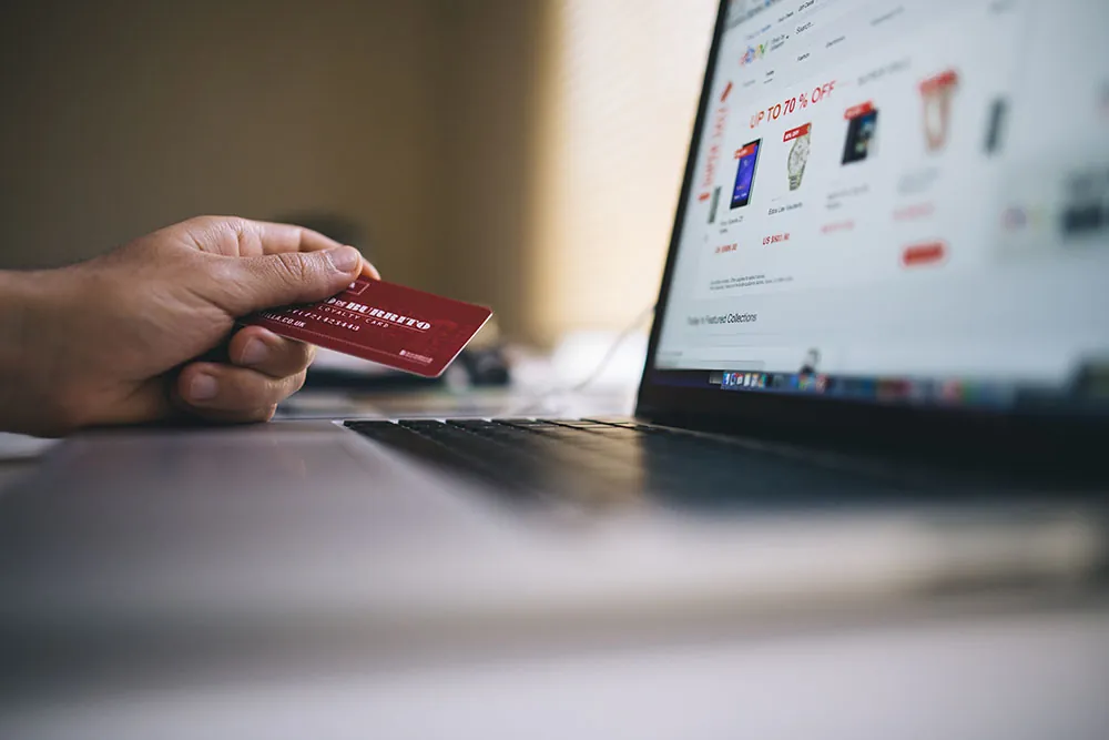 A photo shows a person making a purchase online with a credit card.