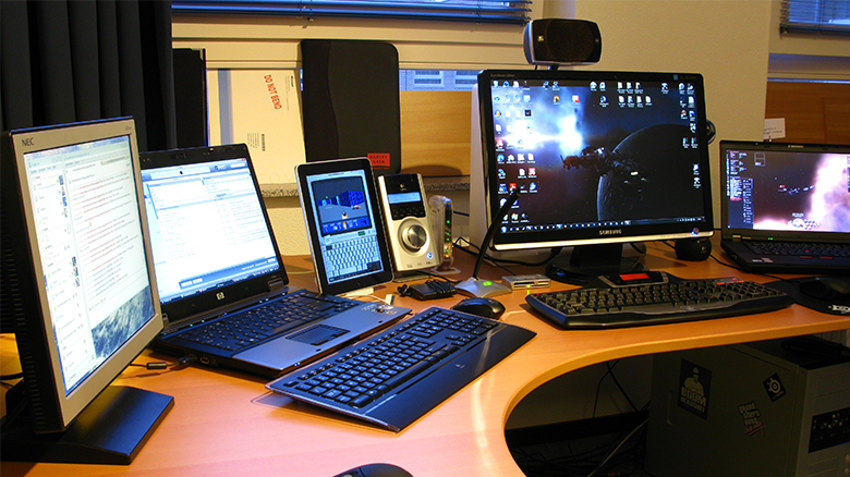 Photo with several laptops hooked up to flat screen monitors