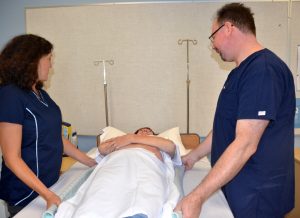 Photo showing boosting of a simulated resident with a lift sheet