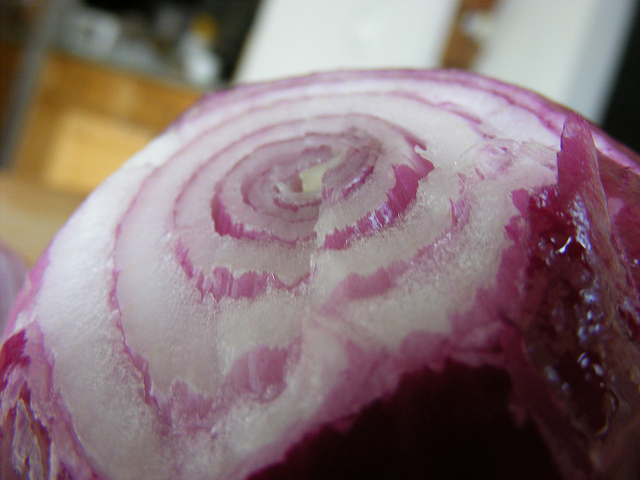 "Close-up image of a red onion showing visible concentric rings and layers."