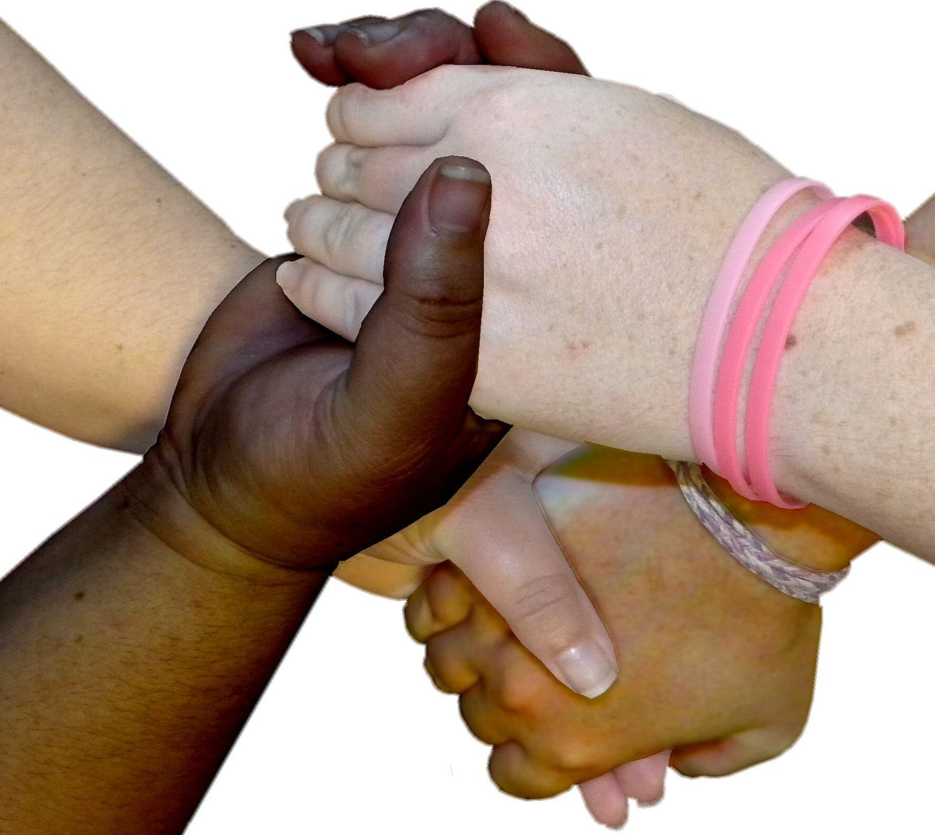 Four hands of different skin tones are clasped together in a supportive manner. Two hands are darker-skinned, and two hands are lighter-skinned. One of the lighter-skinned hands is wearing pink wristbands, and the other is wearing a braided bracelet. The background is white. This image symbolizes diversity, solidarity, and cooperation among people from different backgrounds.