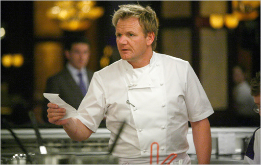 "Gordon Ramsey, the chef. in a white uniform holds a piece of paper while standing in a kitchen. The kitchen features various utensils and equipment, with warm lighting creating an inviting atmosphere."