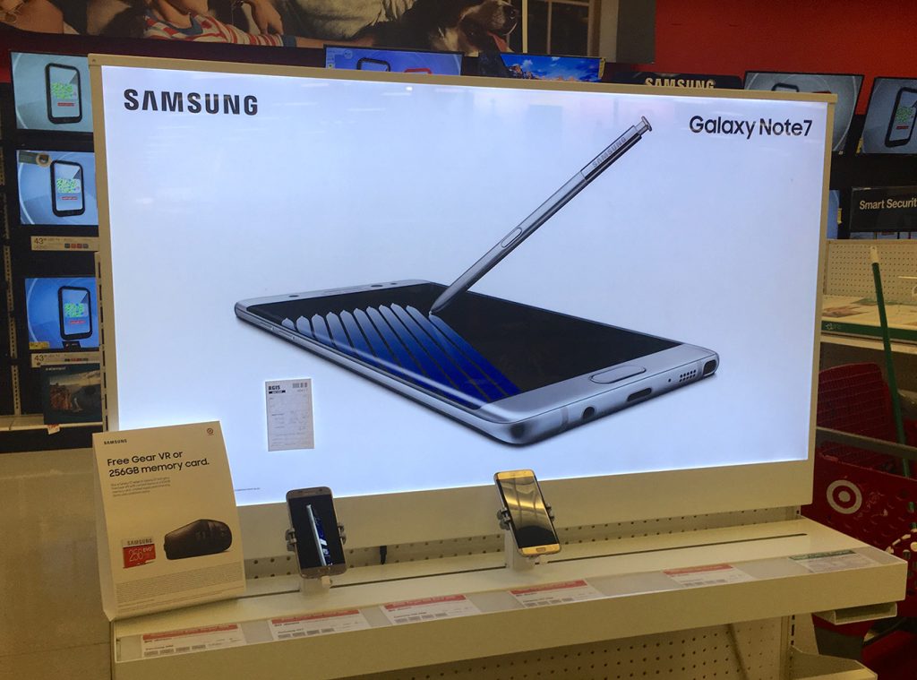 Photo of a Samsung Galaxy Note with a large advertisement behind it.