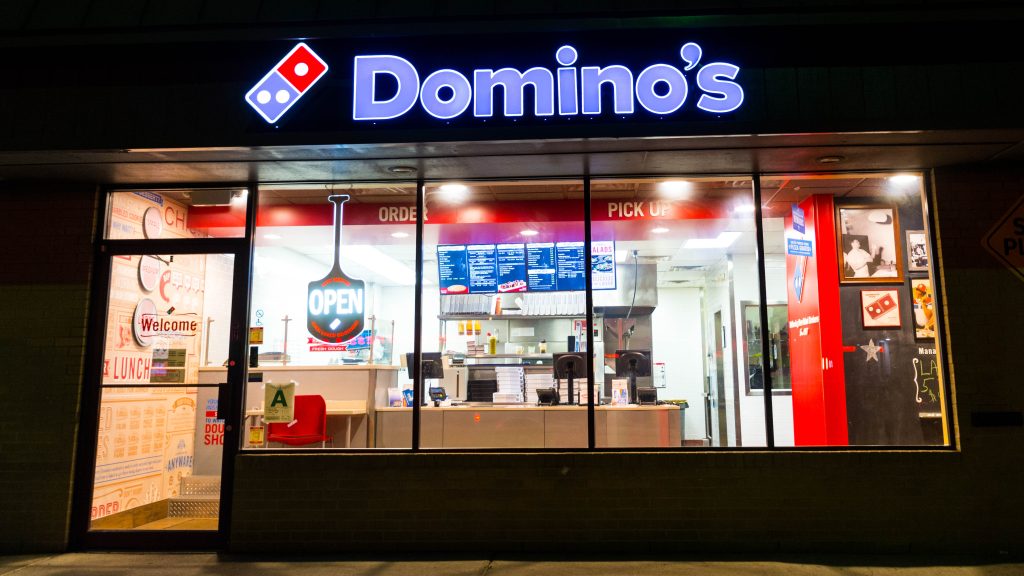 Photo of a Domino's store taken at night.